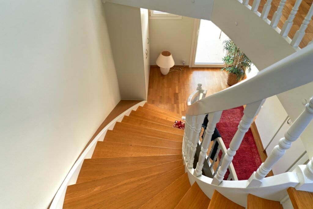 Escalier en bois avec rampe blanche, configuration fréquente pour un monte-escalier droit